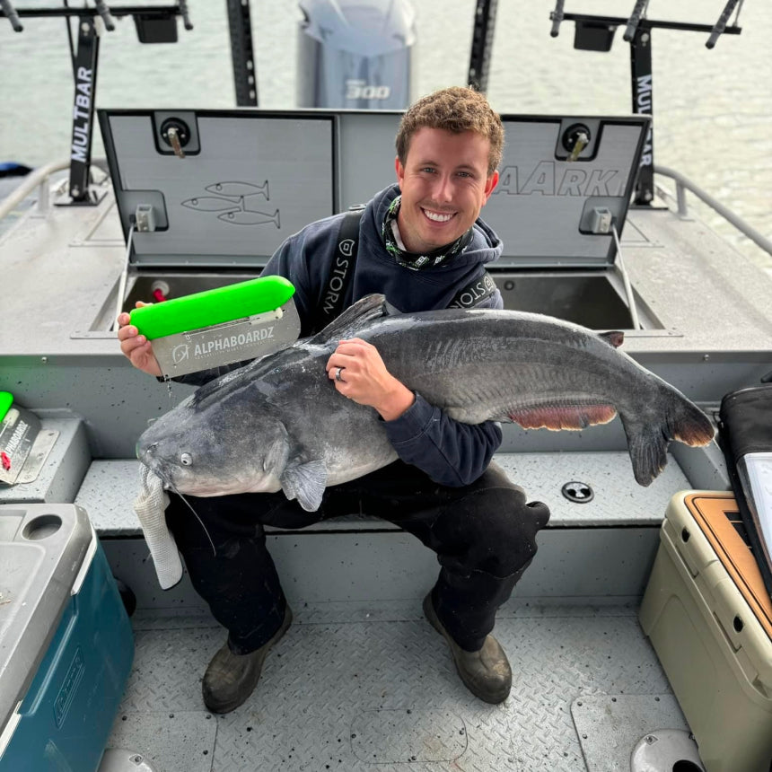 Angler smiling while holding a large fish caught using an Alphaboardz planer board.